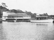 Side view of Keystone Pavilion and dock. Boat parked at dock with man standing on dock